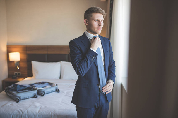Νεαρός επιχειρηματίας στο κοστούμι στο δωμάτιο - Φωτογραφία, εικόνα