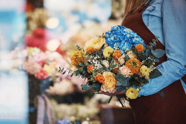 Nuori tyttö kukkakimppu myymälässä
 - Valokuva, kuva