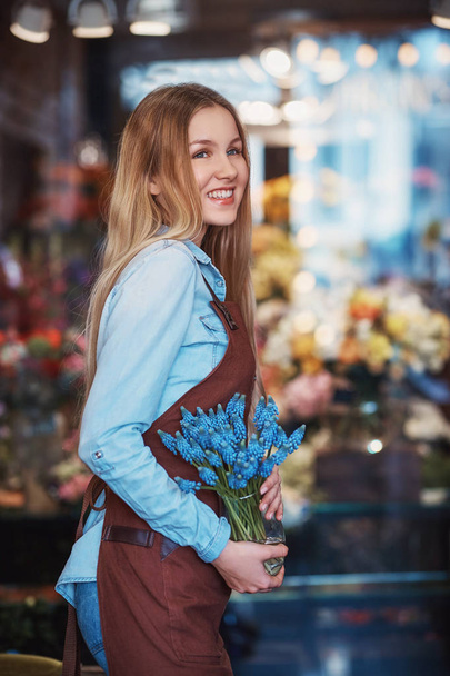 Smiling girl with flowers - Valokuva, kuva