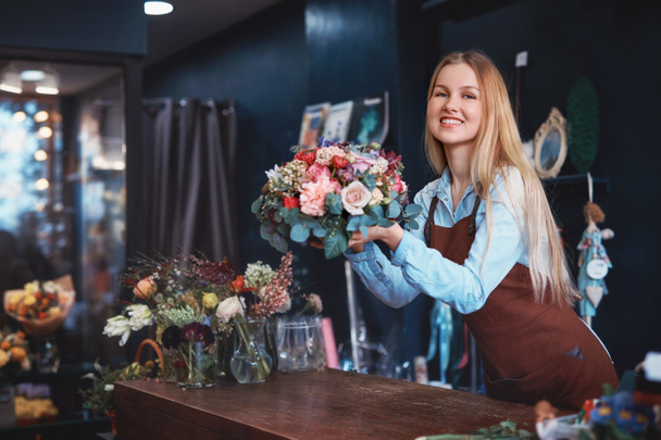 Smiling girl in a flower shop - Photo, Image