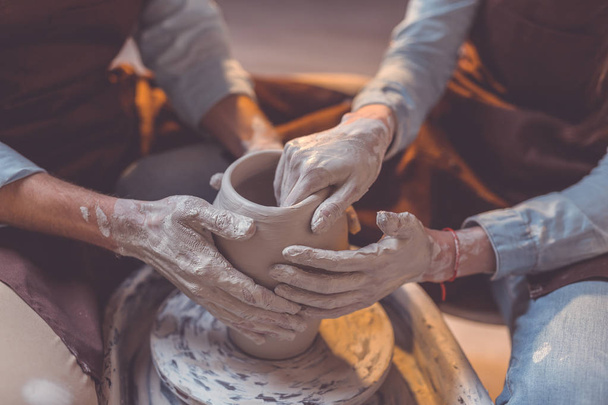 Human hands at the potter's wheel - Foto, imagen