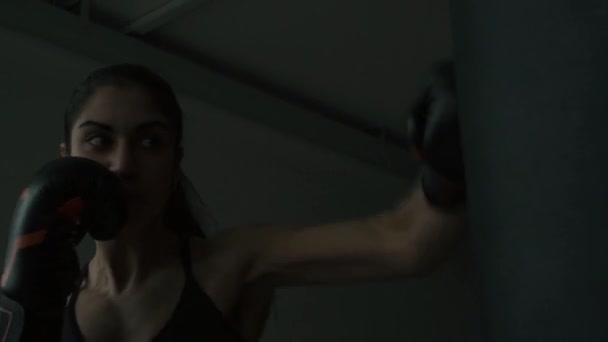 Boxer žena udeří boxovací pytel v tělocvičně - Záběry, video