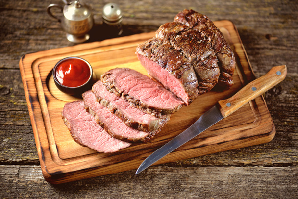 Roast beef medium on a wooden board. Rustic style. - Photo, Image