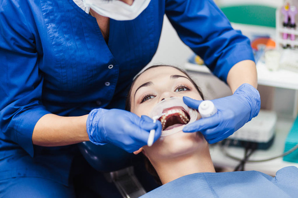Dentist holding tooth whitening procedure - Фото, зображення