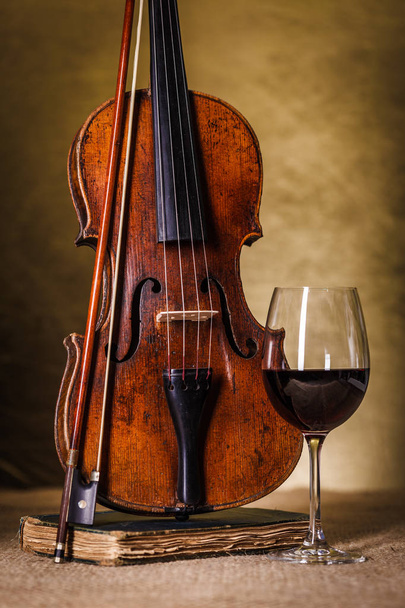 Classical old violin with red wine glass  - 写真・画像