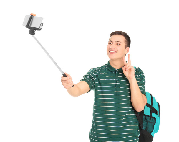 Young handsome man taking selfie against white background - Φωτογραφία, εικόνα