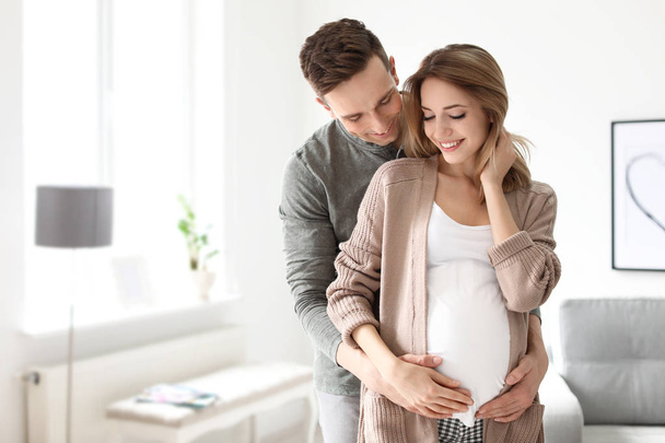 Young pregnant woman with her husband at home - Foto, imagen