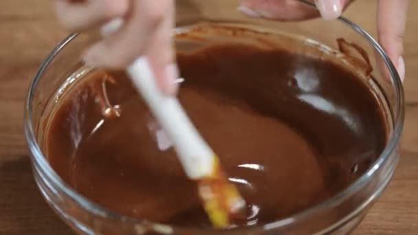 Gesmolten chocolade roert smelten Chocolatefemale handen in kom. - Video