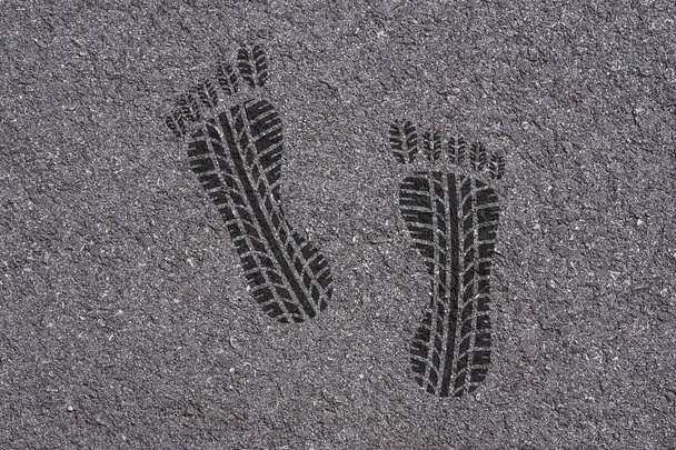 Reifenprofil kombiniert mit der Form eines Barfuß-Fußabdrucks auf Asphalt Hintergrundstruktur - Foto, Bild