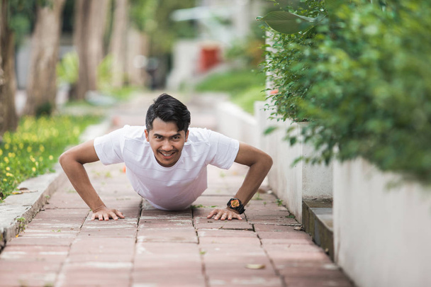 sporty man push up and smiling - 写真・画像