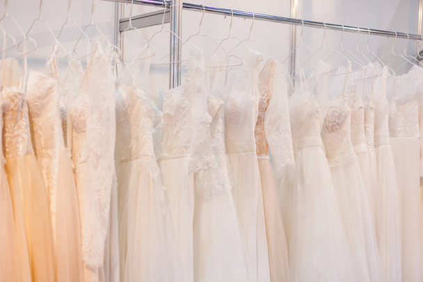 Rack with many wedding dresses. - 写真・画像