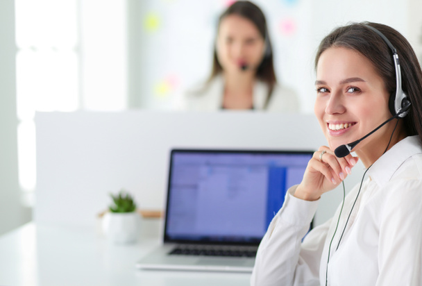 Smiling businesswoman or helpline operator with headset and computer at office - Фото, изображение