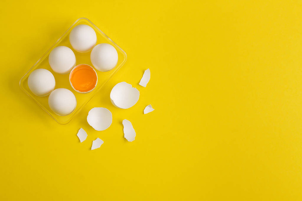 Baking flat lay background with eggs and eggshell on yellow. - Photo, image