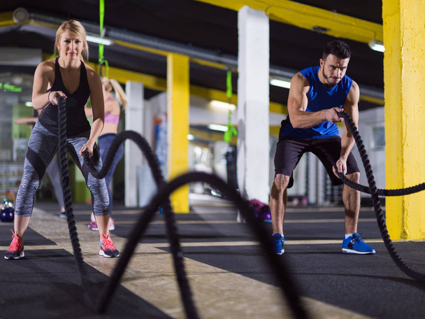 sports couple doing battle ropes crossfitness exercise - Φωτογραφία, εικόνα