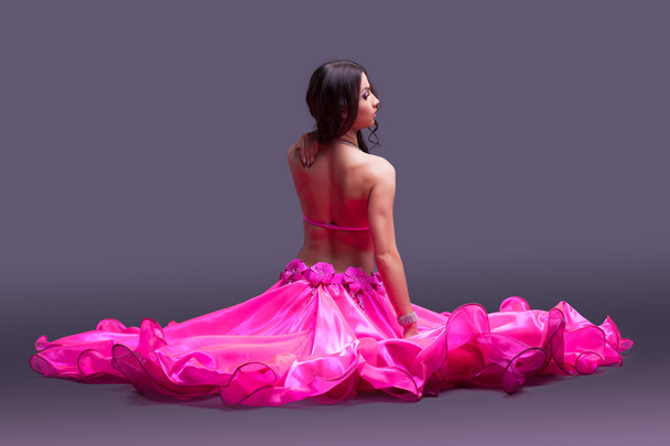Dancer in pink costume sitting on floor - Foto, Imagen