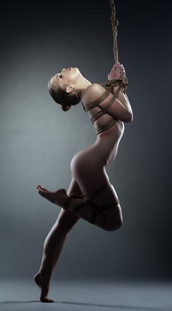 Pretty naked woman with shibari in studio - Photo, image