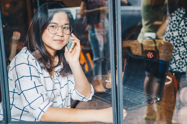 Έξυπνα γυαλιά γυναικών επιχειρηματιών χρησιμοποιούν κινητό τηλέφωνο στο κατάστημα καφέ - Φωτογραφία, εικόνα