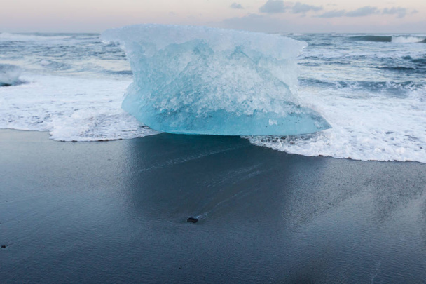 Iceberge op zwarte zand strand over Jokulsarlon diamon strand, winterseizoen IJsland natuurlijke landschap  - Foto, afbeelding