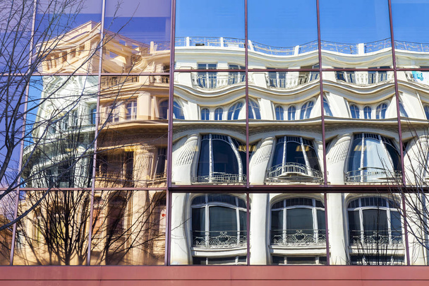 NICE, FRANCE, on March 6, 2018. Old houses are reflected in a glass wall of the modern building - Foto, afbeelding