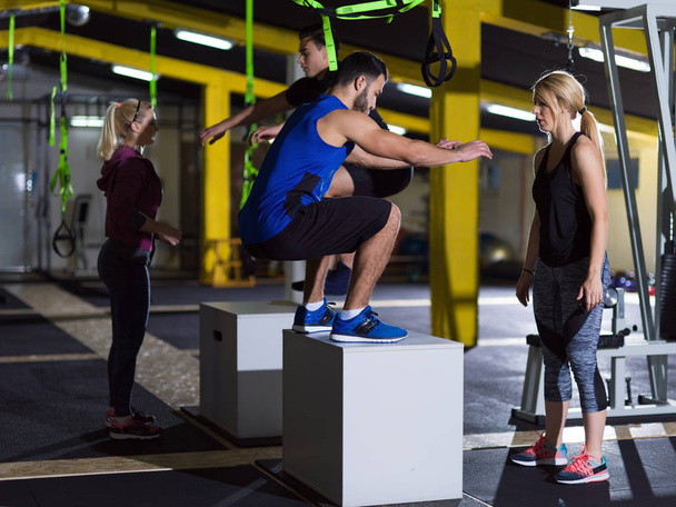 athletes working out  jumping on fit box - Foto, afbeelding