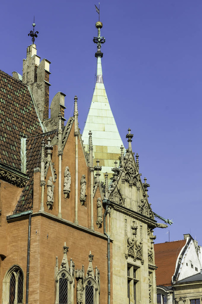 Homlokzatok, tetők, szobrok, kő dekoráció és a középkori városháza tornya. Építészeti - gótikus és barokk kevert stílus. Vroslav, Lengyelország. - Fotó, kép