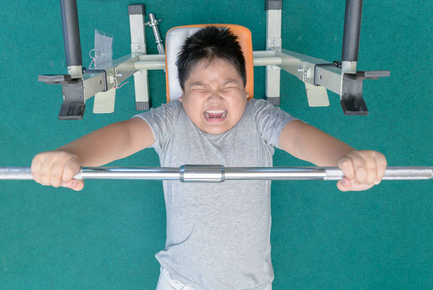 Obese fat boy weightlifting in fitness room, - Fotoğraf, Görsel