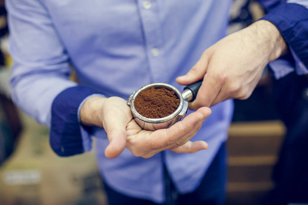 Picture of barista man with ground coffee in hands - Photo, Image