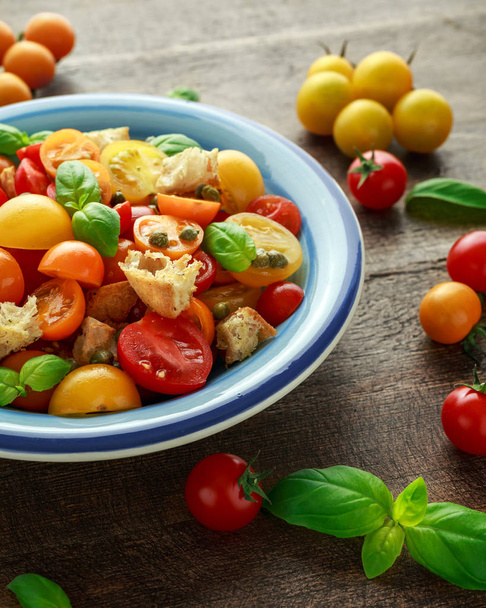 Panzanella domowe, tradycyjne włoskie Sałatka z pomidorów z czerwony, żółty, pomarańczowy pomidory, kapary, bazylia i ciabatta grzankami. Zdrowe jedzenie lato. - Zdjęcie, obraz