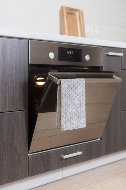 熱い空気換気空オープン電気オーブン。それに掛かっている灰色のタオルでオーブンのドア - 写真・画像