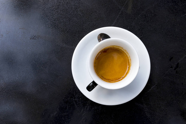 Kawa z pianką w Pucharze biały na czarnym stole Espresso - Zdjęcie, obraz