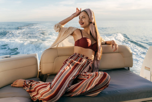 uma menina elegante de luxo relaxa em um iate, foi em uma viagem marítima, ri
 - Foto, Imagem