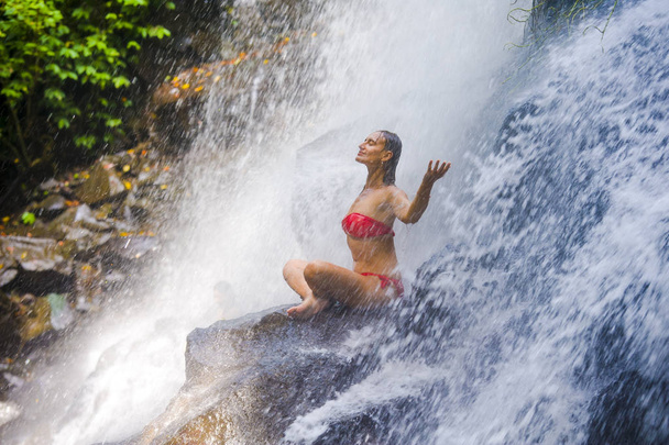 young attractive and happy 30s woman with fit body practicing yoga wet under tropical paradise waterfall stream in meditation and relaxation - Foto, imagen
