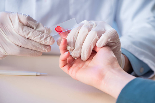 Medico che preleva campioni di sangue dal dito - Foto, immagini