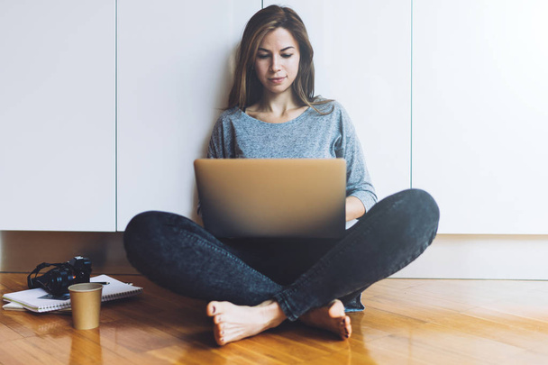 Young woman sitting on a floor and using laptop  - Φωτογραφία, εικόνα