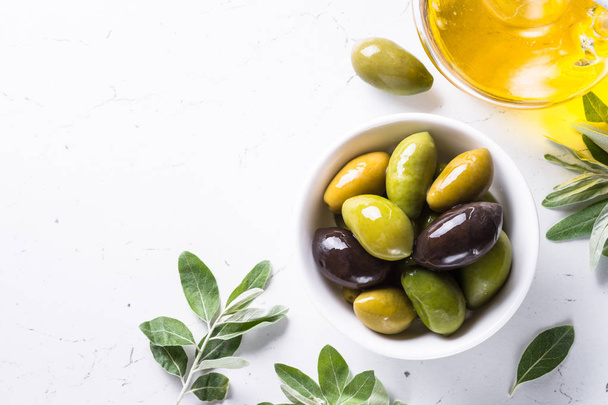 Aceitunas y aceite de oliva sobre blanco
. - Foto, imagen