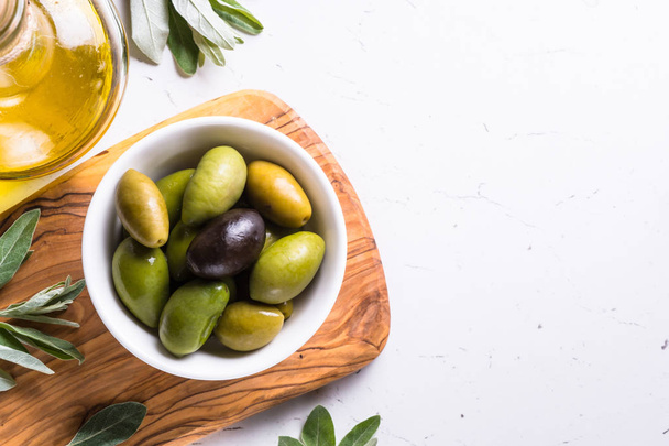 Olives and olive oil on white. - Zdjęcie, obraz