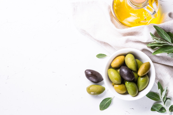 Aceitunas y aceite de oliva sobre blanco
. - Foto, Imagen