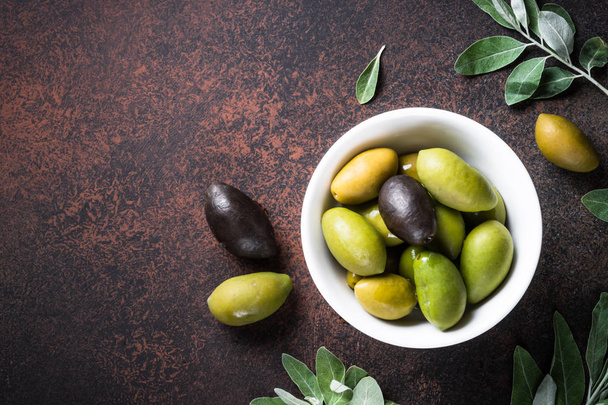 Olive e olio su pietra scura tavolo vista dall'alto
. - Foto, immagini
