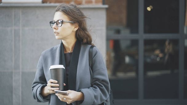 Businesswoman in glasses holding coffee outside - Foto, Imagem