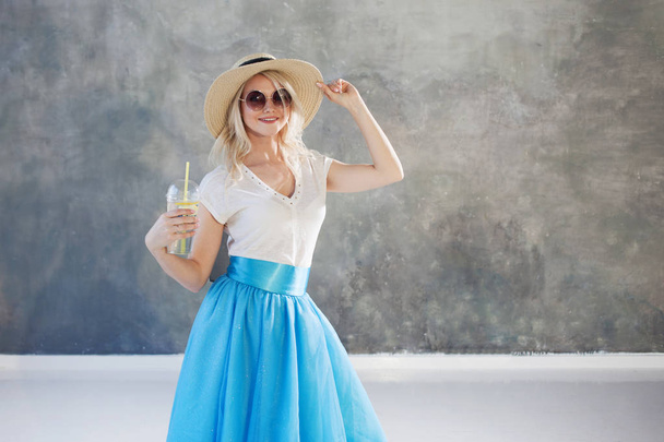 Młody piękny blond kobieta w słomkowy kapelusz. Okulary przeciwsłoneczne styl lato. - Zdjęcie, obraz