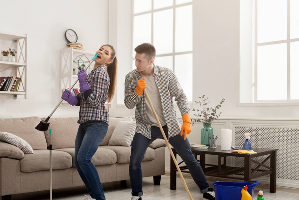 Молода пара прибирає будинок, розважається
 - Фото, зображення