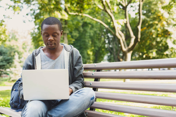 Homem concentrado trabalhando em seu laptop ao ar livre
 - Foto, Imagem