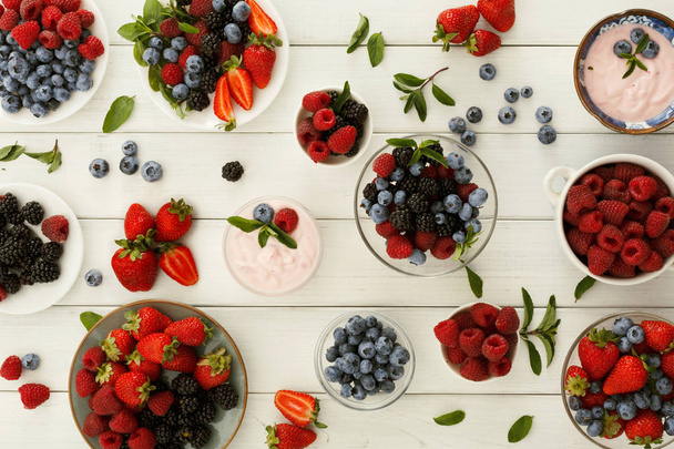 Healthy breakfast with berries and yogurt on white wooden table - Photo, Image