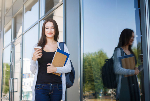 Mladá žena se studenty, knihami a batoh. Pobyt venku před ponaučení a pití kávy - Fotografie, Obrázek