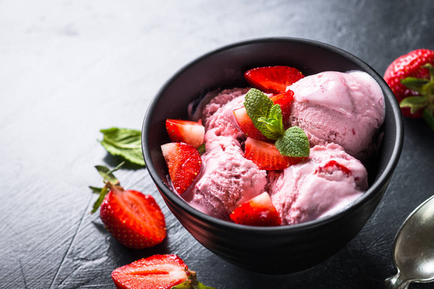 Полуничне морозиво зі свіжими ягодами на чорному
.  - Фото, зображення