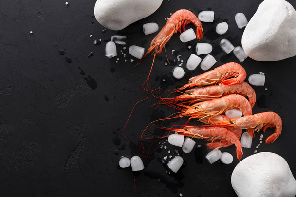 Shrimps with white stones on black background - Foto, afbeelding