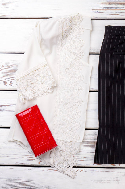 Женская классическая одежда и красный кошелек
. - Фото, изображение