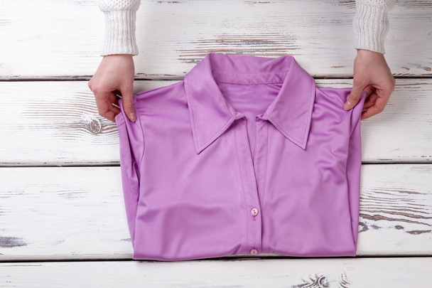 Naisten kädet ja kaunis violetti paita
. - Valokuva, kuva