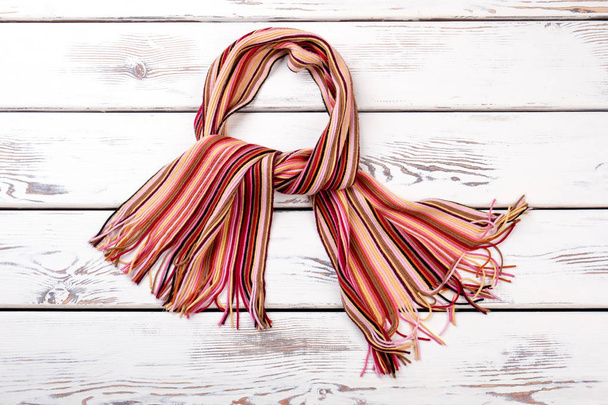 Multicolored striped scarf, wooden background. - Photo, Image