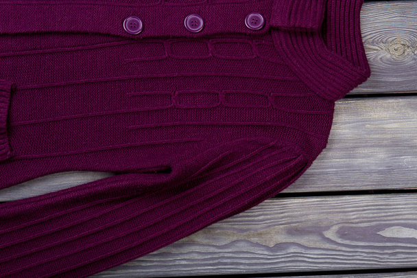 Female knitted cardigan, wooden background. - Photo, Image